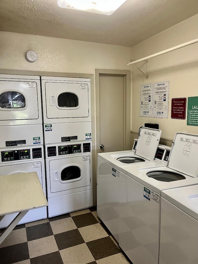 4851 Cedar Springs Rd Unit 391, Dallas, TX 75219 - common laundry area featuring washer and clothes dryer, tile patterned floors, stacked washer / drying machine, and a textured ceiling