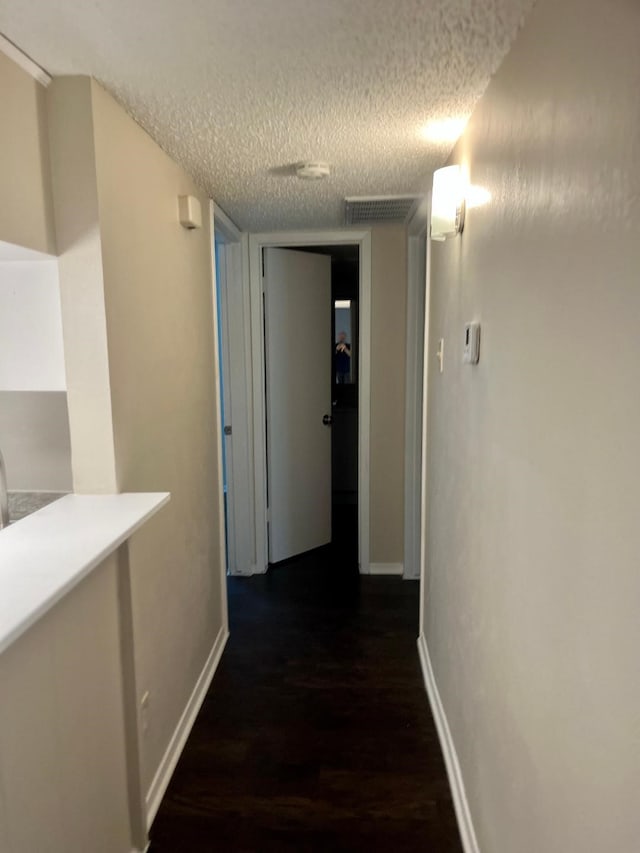 4851 Cedar Springs Rd Unit 391, Dallas, TX 75219 - hall with visible vents, a textured ceiling, baseboards, and dark wood-style floors