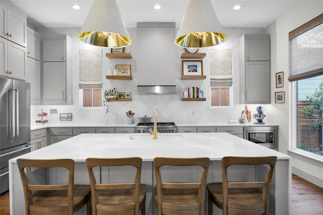 kitchen featuring dark wood-style flooring, backsplash, gray cabinetry, appliances with stainless steel finishes, and a sink