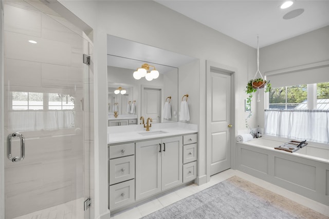 bathroom with tile patterned floors, vanity, a bath, and a stall shower