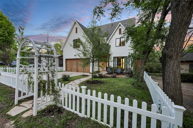 view of front facade with a fenced front yard, a garage, and concrete driveway
