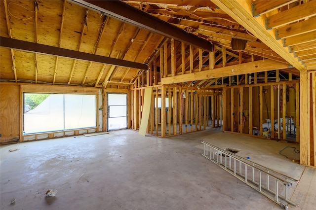 misc room featuring vaulted ceiling and unfinished concrete floors