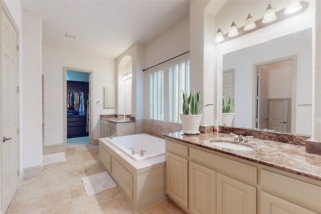 full bathroom with a spacious closet, visible vents, a bath, and vanity