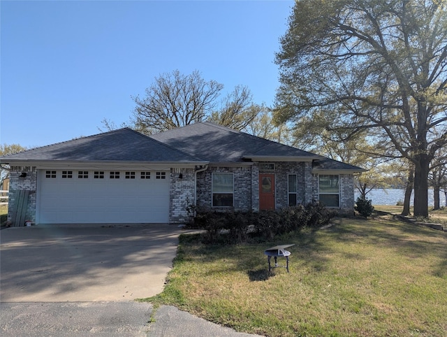 ranch-style house featuring a front yard, a shingled roof, a garage, and concrete driveway