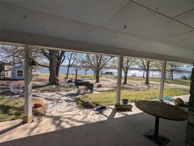 view of patio / terrace with grilling area, an outdoor structure, and a water view