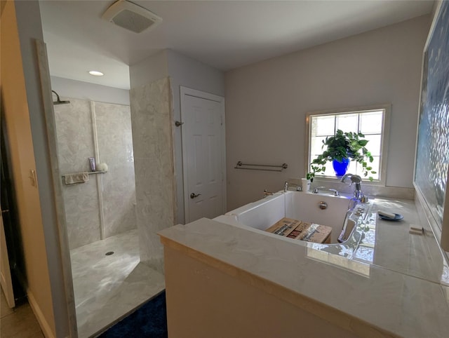 bathroom featuring visible vents, walk in shower, and a washtub