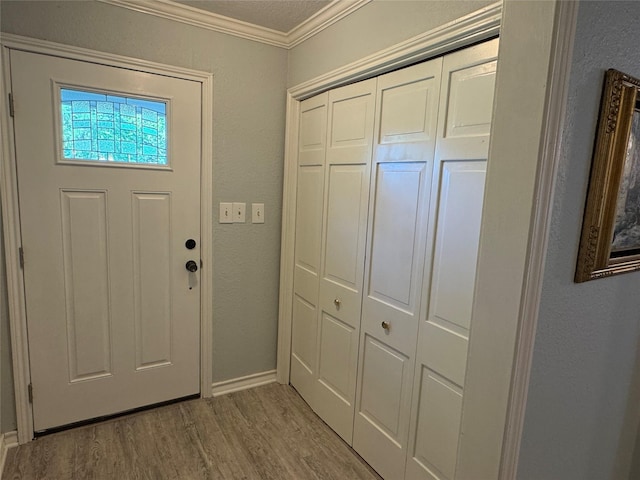 entrance foyer with crown molding, wood finished floors, and baseboards