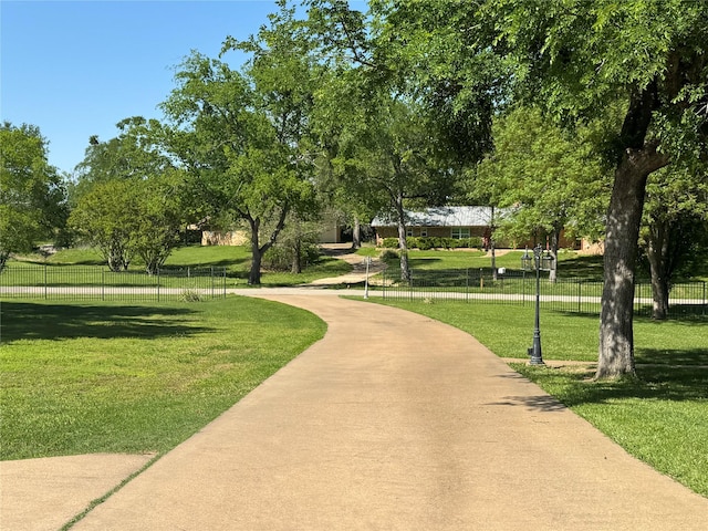 view of community featuring fence and a lawn