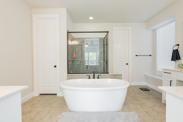 bathroom with tile patterned floors, a shower stall, a soaking tub, and baseboards