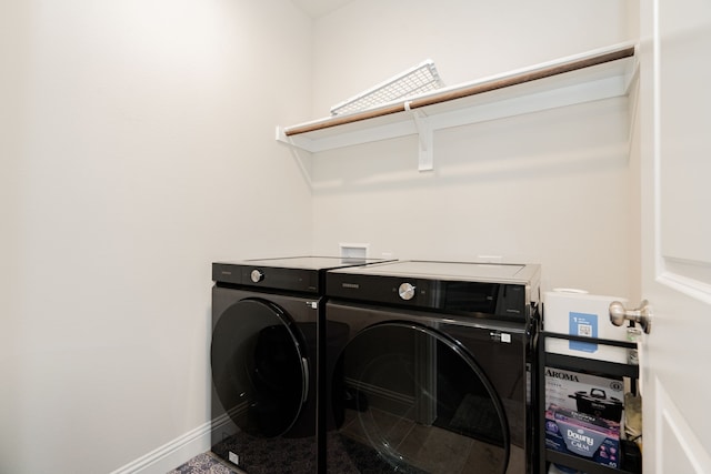 clothes washing area featuring baseboards, separate washer and dryer, and laundry area