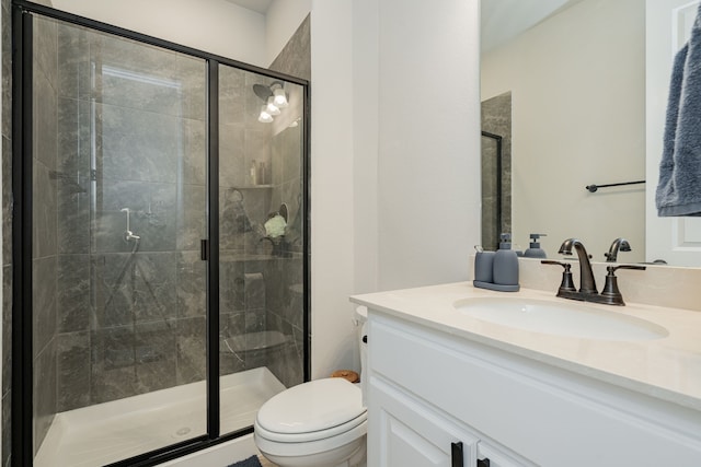 bathroom with a shower stall, vanity, and toilet