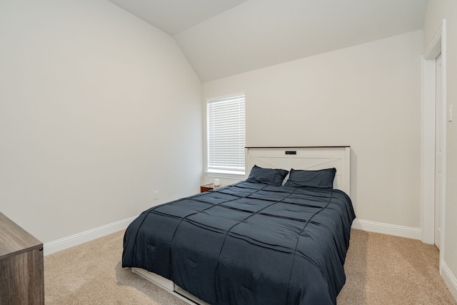 carpeted bedroom featuring baseboards and vaulted ceiling