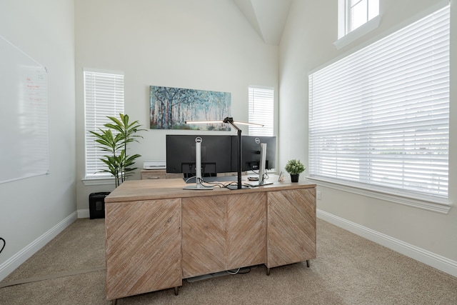 office area with light carpet, baseboards, and a healthy amount of sunlight