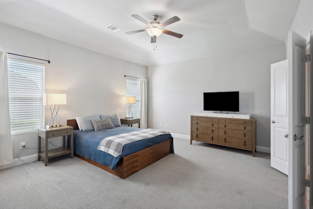 carpeted bedroom featuring lofted ceiling, baseboards, visible vents, and ceiling fan