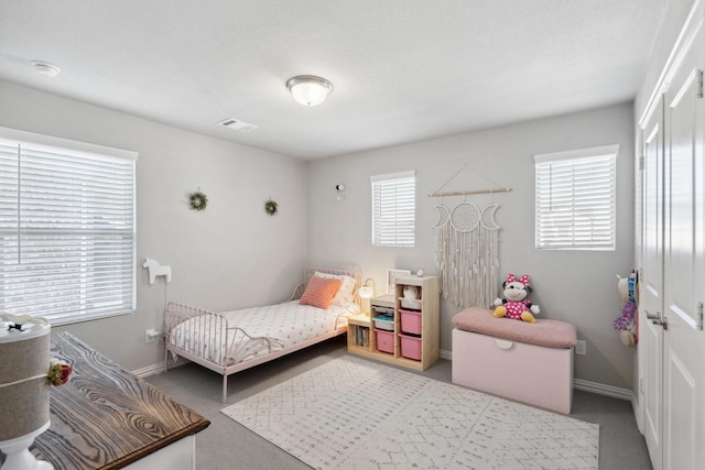 carpeted bedroom featuring baseboards and visible vents