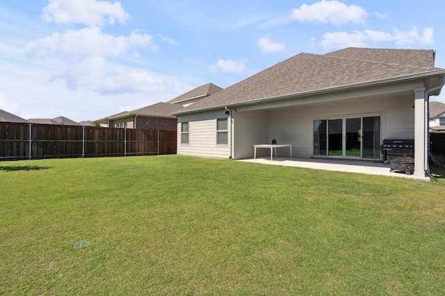 back of property with fence, a patio area, a lawn, and roof with shingles