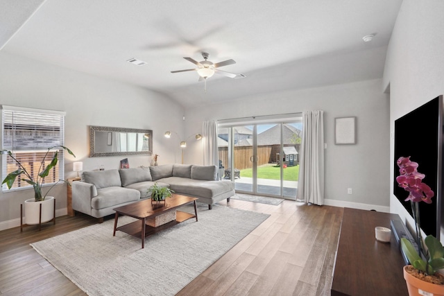 living area featuring visible vents, wood finished floors, baseboards, and ceiling fan
