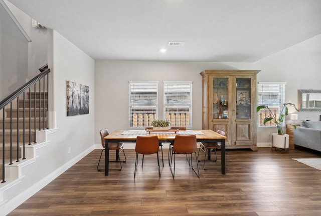 dining space with dark wood finished floors, stairway, visible vents, and baseboards