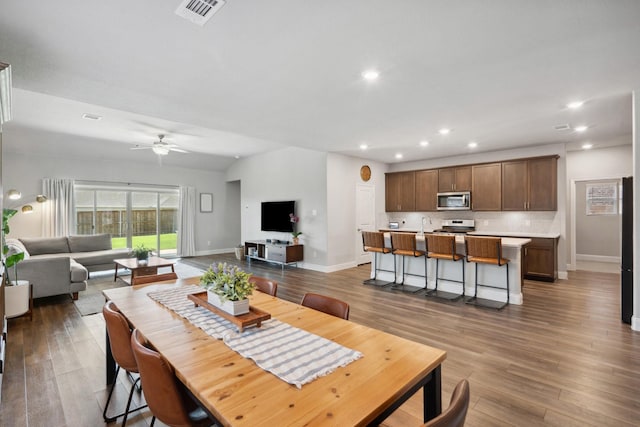 dining space with baseboards, wood finished floors, visible vents, and recessed lighting
