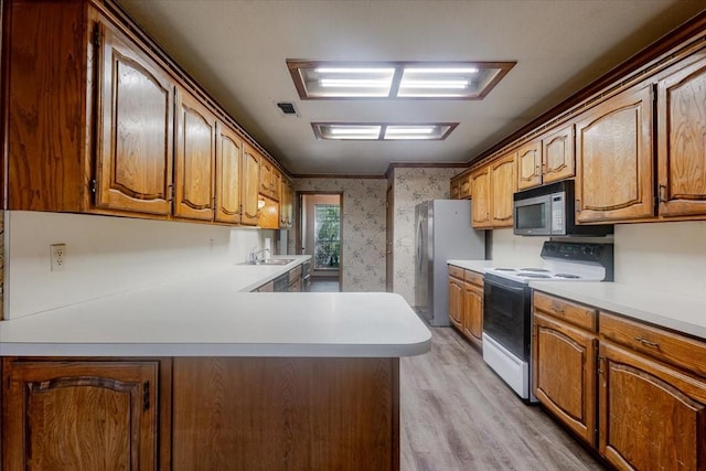 275 Salesville Rd, Mineral Wells, TX 76067 - kitchen with wallpapered walls, stainless steel appliances, visible vents, a sink, and light wood-style flooring
