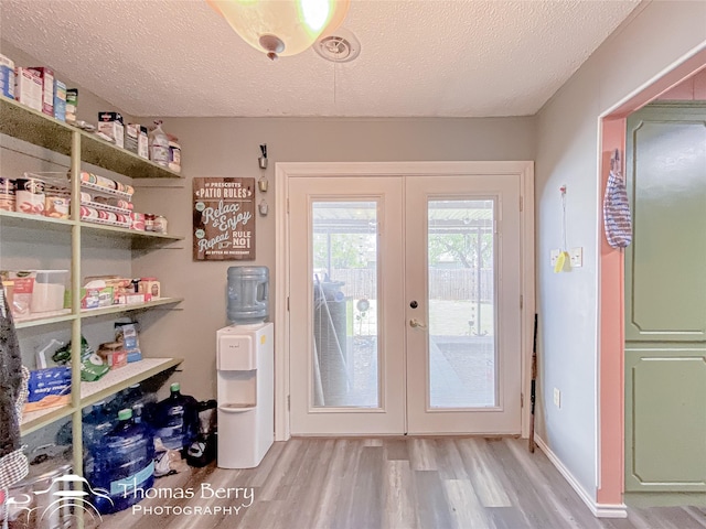 entryway featuring a textured ceiling, wood finished floors, and french doors