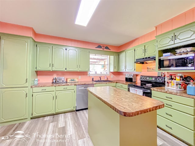 kitchen with a sink, appliances with stainless steel finishes, light countertops, under cabinet range hood, and light wood-type flooring