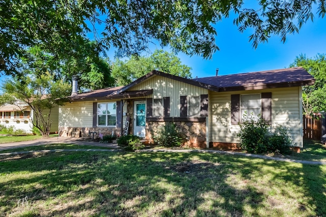 single story home with a front lawn and stone siding