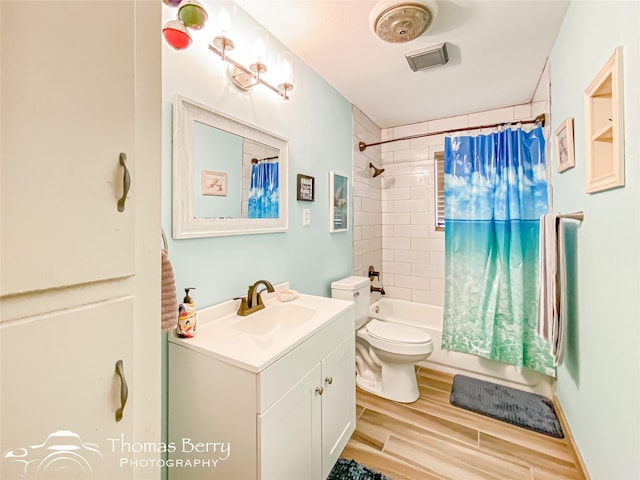 full bath featuring wood finished floors, shower / bathtub combination with curtain, toilet, vanity, and visible vents