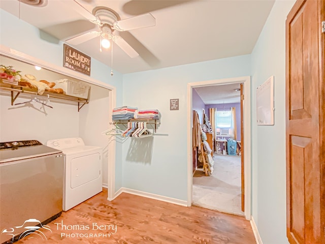 washroom with light wood-style flooring, ceiling fan, baseboards, separate washer and dryer, and laundry area