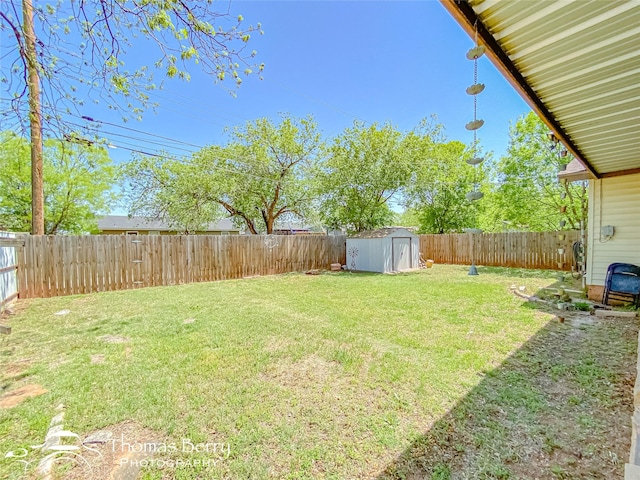 view of yard with a storage unit, a fenced backyard, and an outdoor structure
