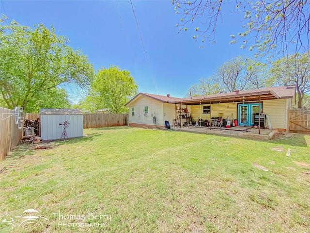 rear view of property featuring an outdoor structure, a patio area, a storage shed, a lawn, and a fenced backyard