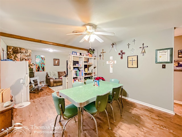 dining space featuring baseboards, a ceiling fan, and light wood-style flooring