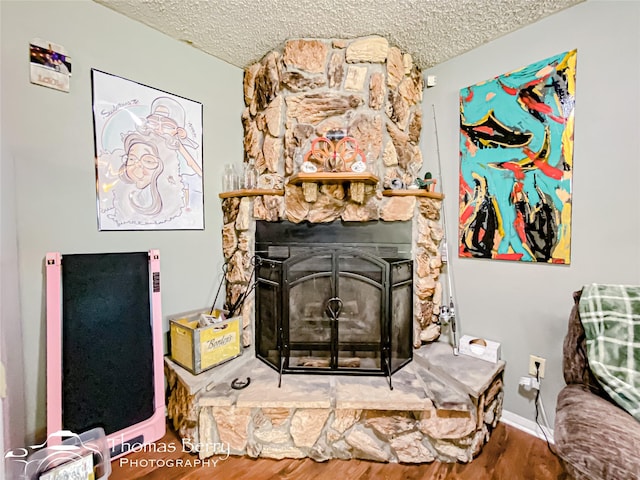 interior details featuring wood finished floors, a textured ceiling, and a fireplace
