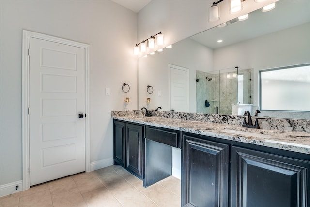 bathroom with a sink, baseboards, a shower stall, and double vanity