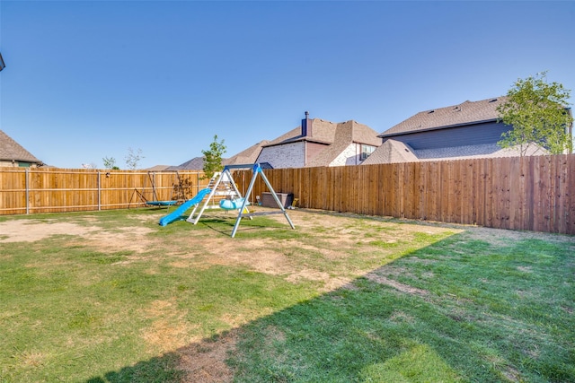 view of yard with a fenced backyard and a playground