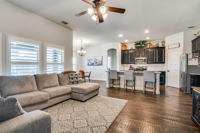 living room with arched walkways, recessed lighting, visible vents, and ceiling fan with notable chandelier