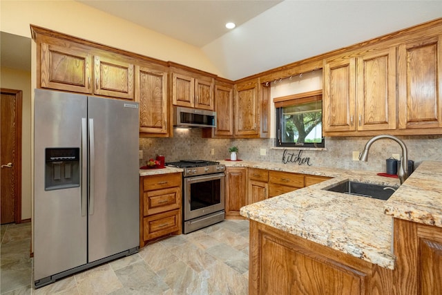 kitchen featuring vaulted ceiling, stainless steel appliances, brown cabinets, and a sink