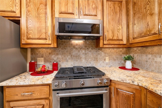 kitchen featuring backsplash, appliances with stainless steel finishes, and brown cabinets