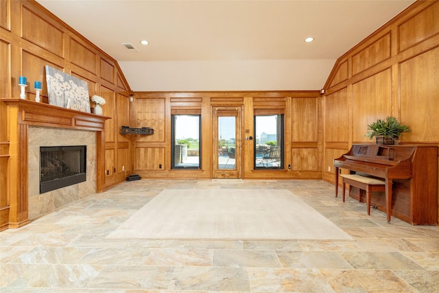 living room with visible vents, a fireplace, wood walls, and lofted ceiling