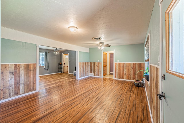 1206 John Reagan St, Benbrook, TX 76126 - spare room with a ceiling fan, wood finished floors, a textured ceiling, a wainscoted wall, and wooden walls