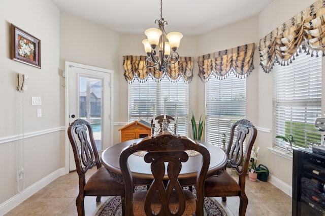dining room with light tile patterned flooring, an inviting chandelier, baseboards, and plenty of natural light