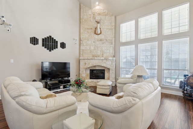 living area featuring high vaulted ceiling, a fireplace, and dark wood-style floors