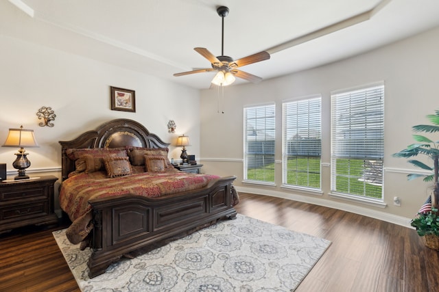 bedroom featuring ceiling fan, dark wood-style flooring, baseboards, and multiple windows