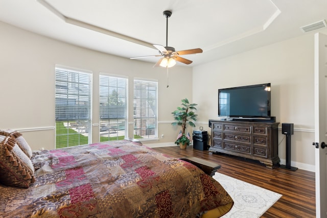 bedroom featuring visible vents, baseboards, ceiling fan, and wood finished floors