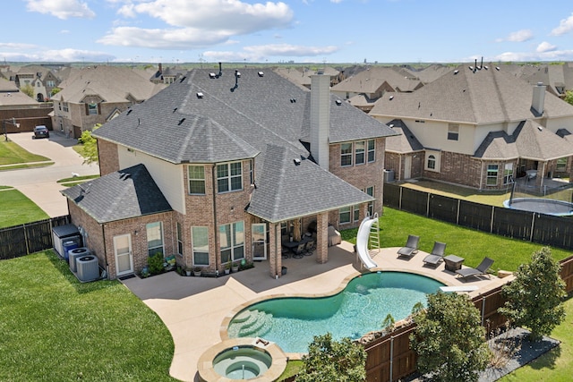 view of swimming pool with a patio area, a water slide, a residential view, and a fenced backyard