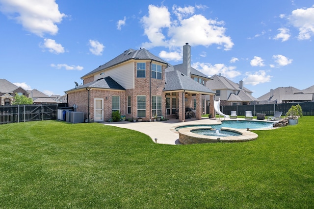 rear view of house with a yard, a patio area, a chimney, a fenced backyard, and brick siding