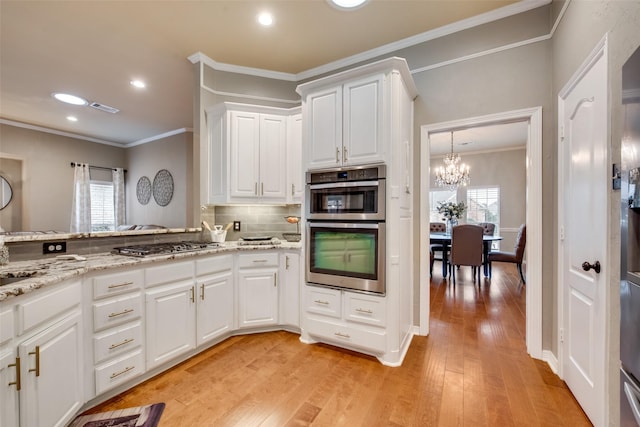 kitchen featuring plenty of natural light, visible vents, an inviting chandelier, and appliances with stainless steel finishes