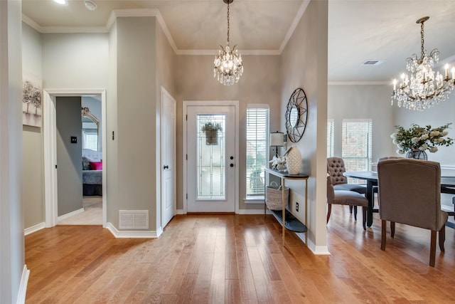 foyer with visible vents, baseboards, light wood finished floors, and a chandelier