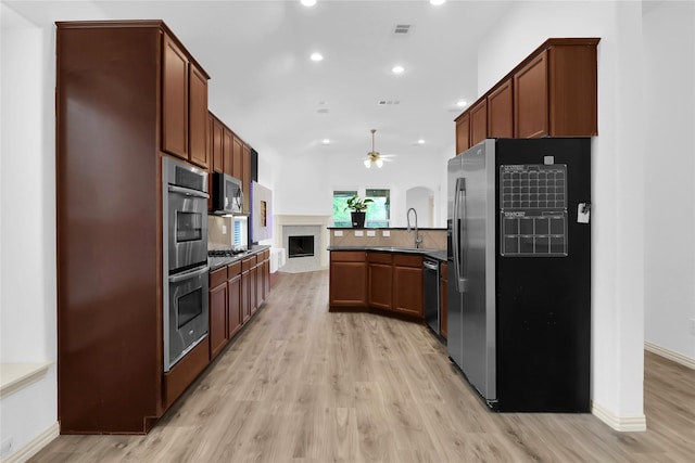 kitchen with a peninsula, recessed lighting, a ceiling fan, light wood-style flooring, and stainless steel appliances