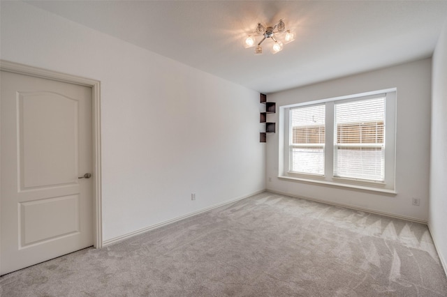 carpeted spare room featuring baseboards